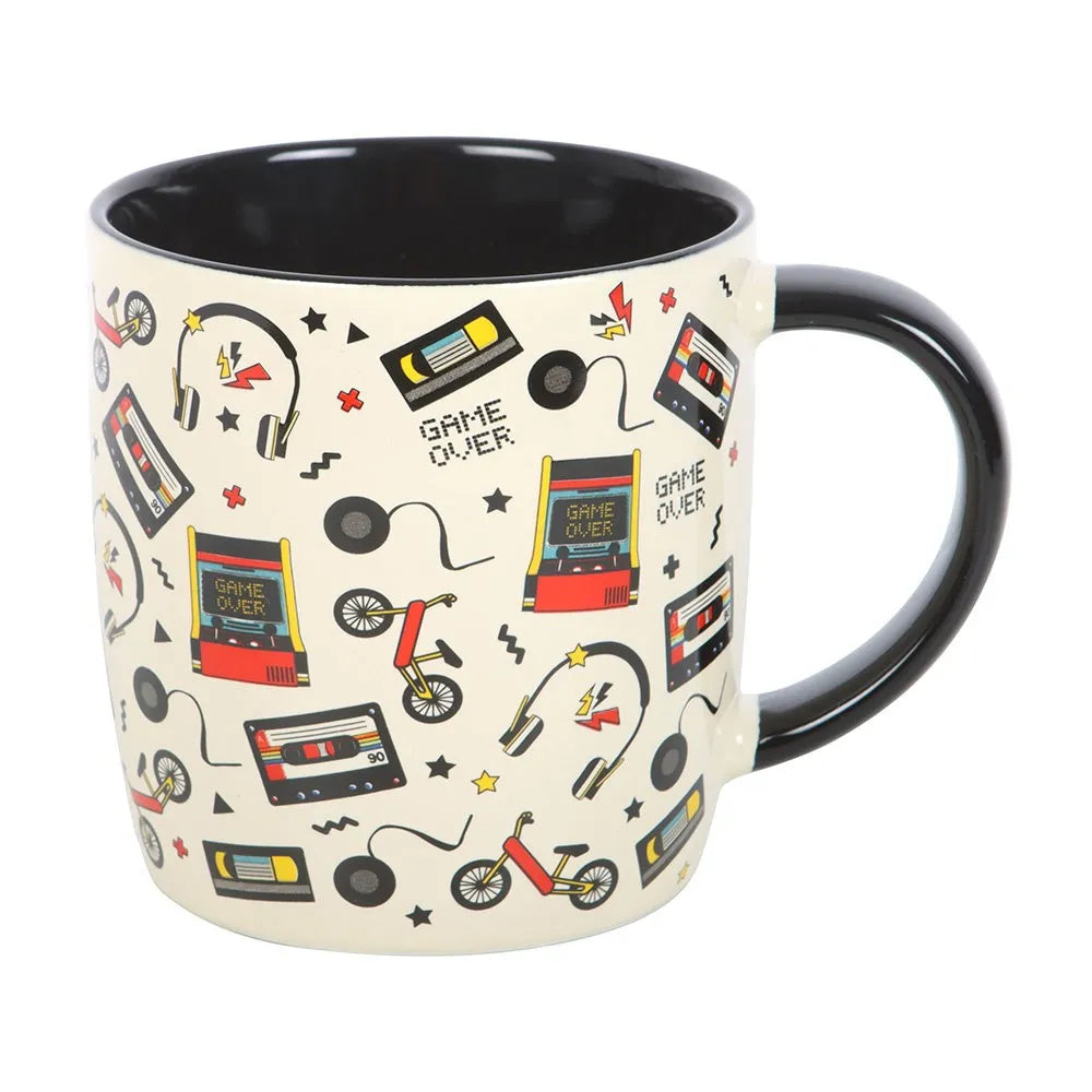 Mug with retro-themed design featuring cassette tapes, game consoles, and other vintage elements on a white background.
