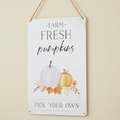 A metal wall sign with hanging Jute. Features farm fresh pumpkin text with illustrations