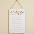 Decorative sign with 'Autumn Magic' text and fall-themed phrases on a beige wall.