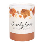 Scented candle with autumn leaf design on a white background