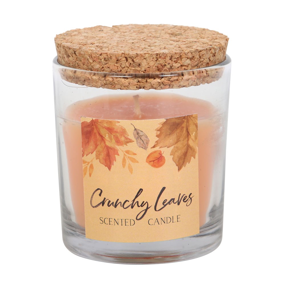 Scented candle in a glass jar with a cork lid and 'Crunchy Leaves' label on a white background