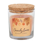 Scented candle in a glass jar with a cork lid and 'Crunchy Leaves' label on a white background
