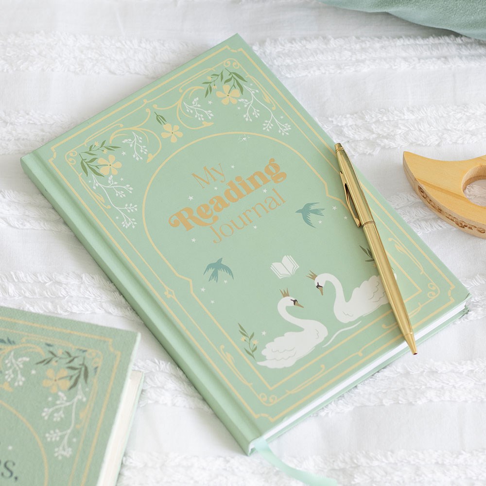 Decorative reading journal with swan illustration and gold pen on a white textured surface