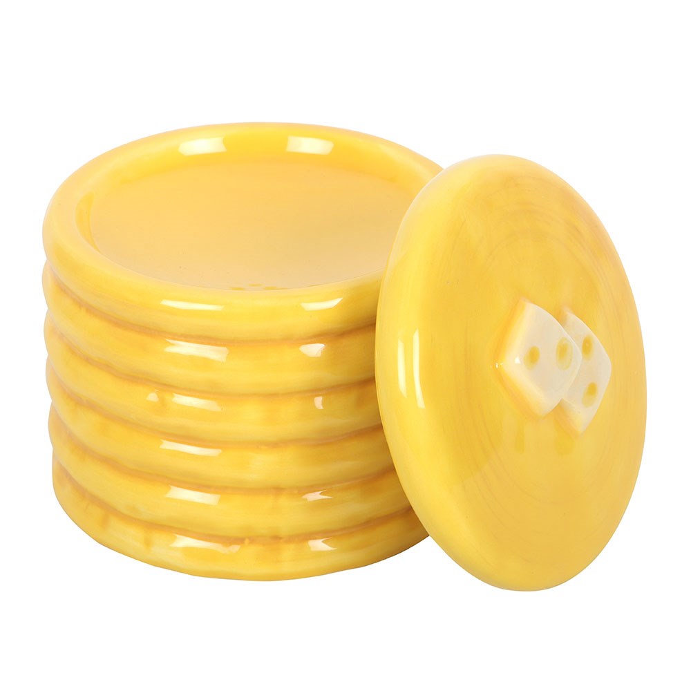 Stack of yellow pancakes oil burner with a pancake lid on a white background
