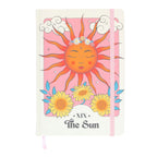 Notebook with a sun design and flowers on a pink background
