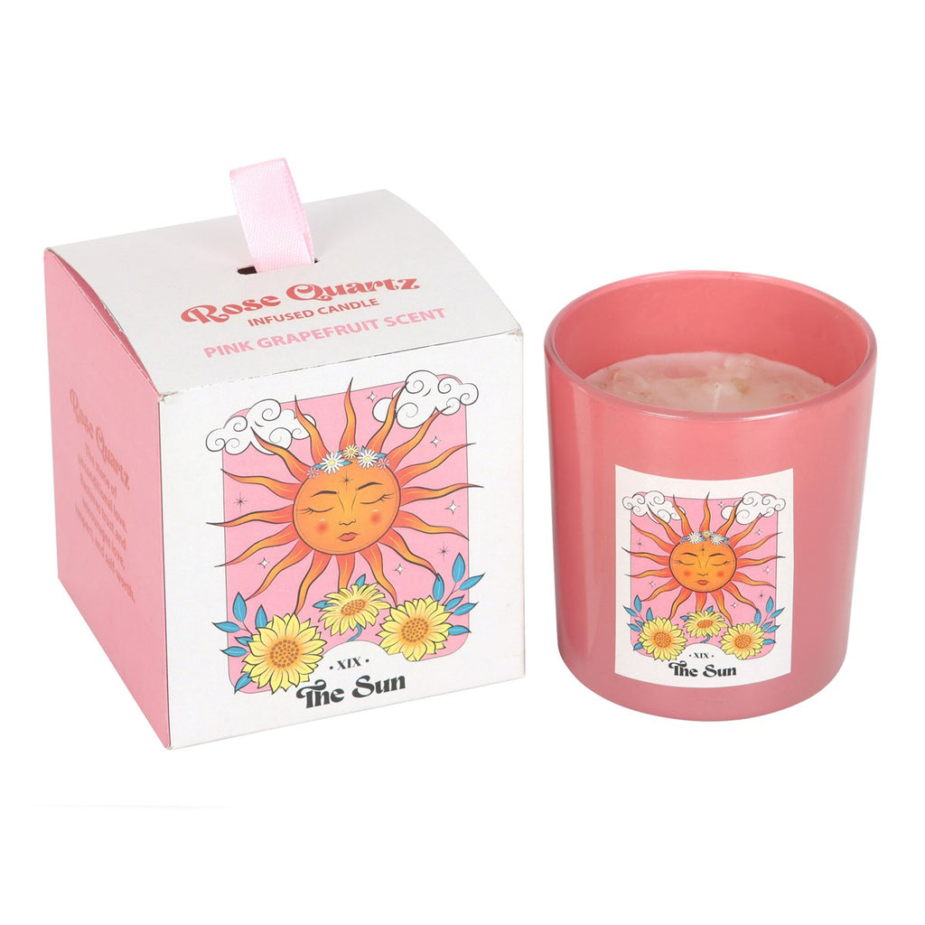 Pink rose quartz candle with sun design and matching packaging on a white background