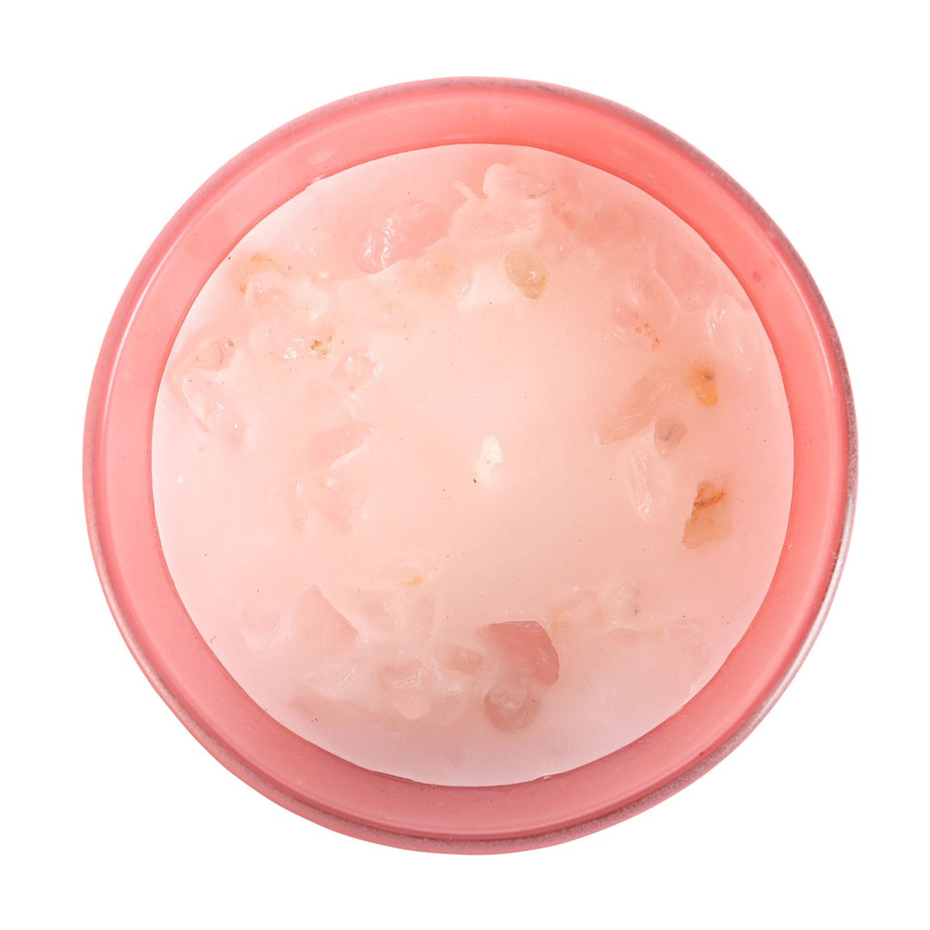 Pink candle with rose quartz on a white background