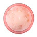 Pink candle with rose quartz on a white background