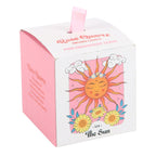Candle packaging with sun design and pink and white color scheme