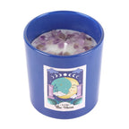 Candle in a blue glass container with a moon design on a white background
