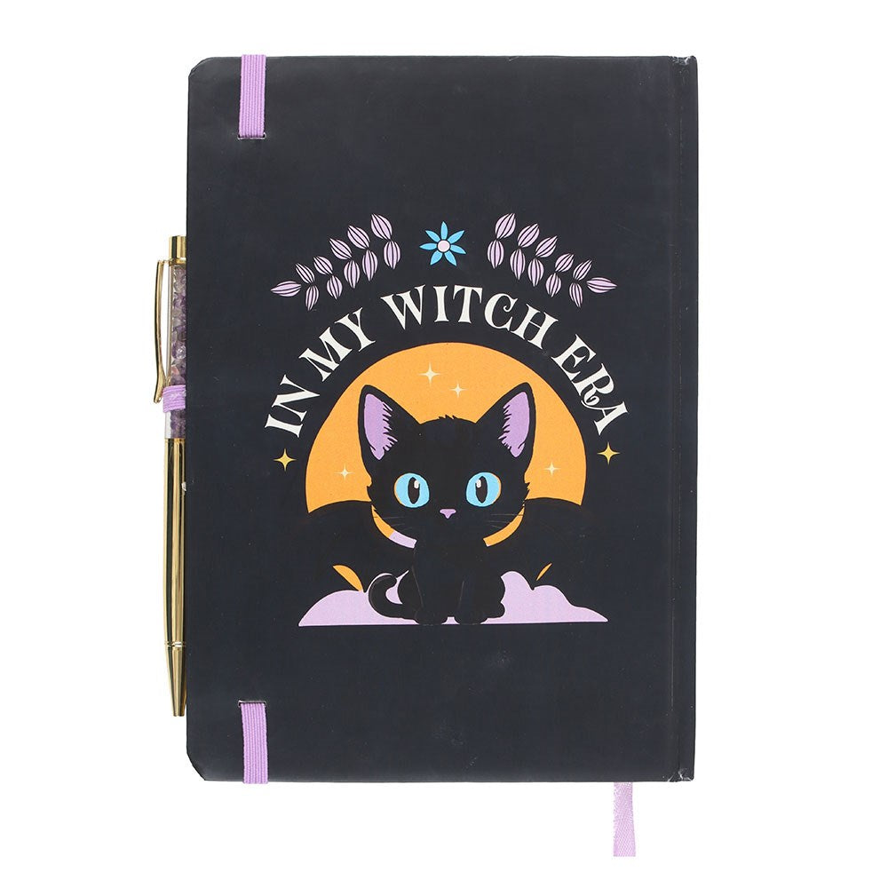 Black notebook with a cat illustration and 'In My Witch Era' text and pen on a white background
