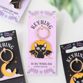 a black cat design Keyring packaging with on a white background