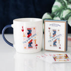 Mug and playing card set with 'King of Our Hearts' design on a table.