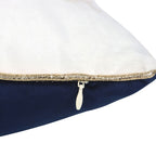 Close-up of a pillow with a gold trim and zipper on a white background