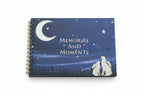 spiral-bound memory book 'Memories and Moments' with a night sky design on a wooden surface.