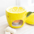Yellow lemon-shaped oil burner with a lit tealight candle on a white background