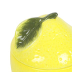 Yellow ceramic lemon with a green leaf on a white background