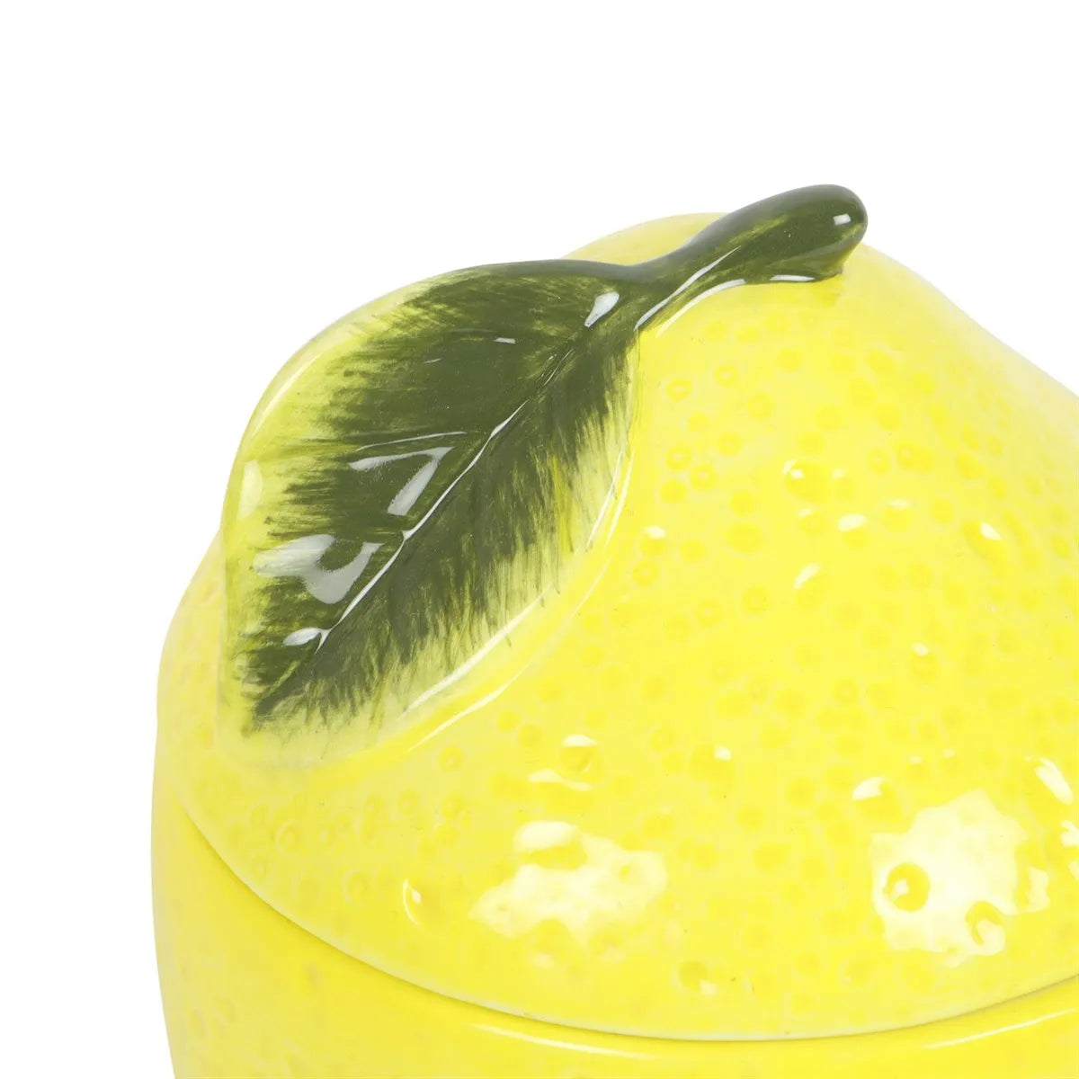 Yellow ceramic lemon with a green leaf on a white background