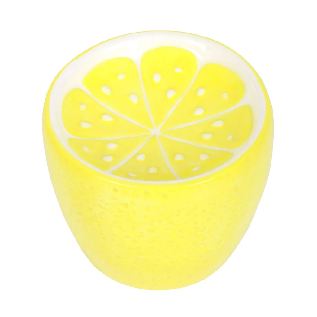 Yellow ceramic oil burner shaped like a lemon sliced on a white background