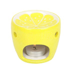 Yellow lemon-shaped oil burner with a lit tealight on a white background