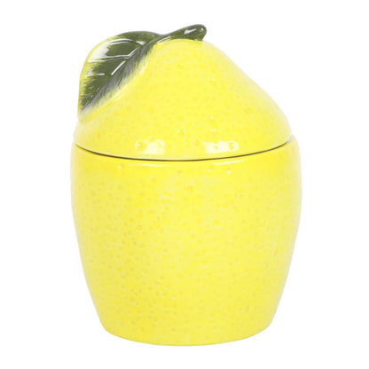 Yellow lemon-shaped oil burner with a lid on a white background