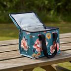 Floral and bee patterned cooler bag on a wooden table outdoors