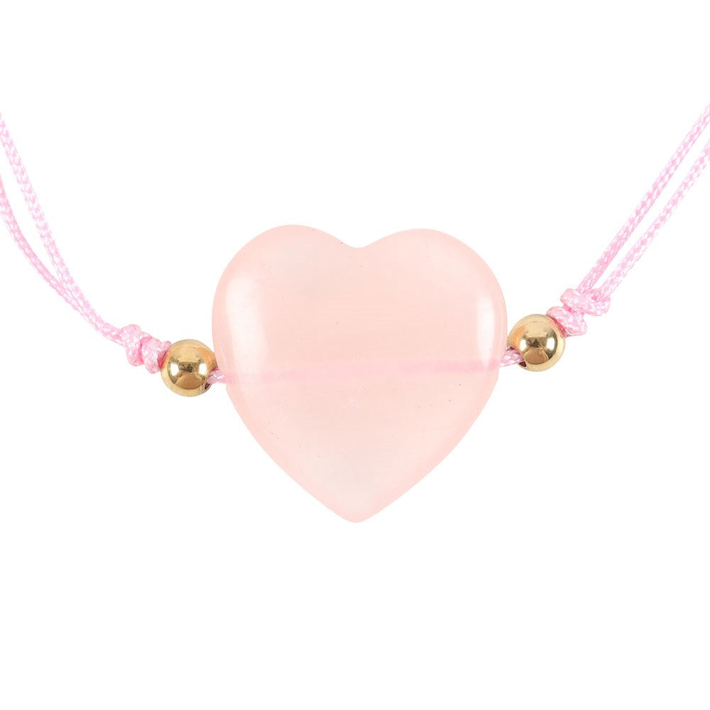 Pink heart-shaped crystal pendant on a pink cord with gold beads against a white background