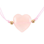Pink heart-shaped crystal pendant on a pink cord with gold beads against a white background
