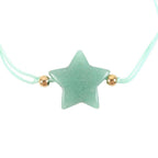 Star-shaped charm on a light blue cord with gold beads against a white background