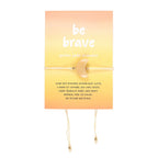 Yellow jade bracelet on an orange card with 'be brave' text