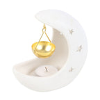 White ceramic moon-shaped oil burner with a gold bowl and candle on a white background