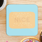 A square coaster with a glossy finish, primarily blue in colour with a 'NICE' biscuit printed in a bold