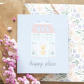 hanging sign with a house illustration and 'this is our happy place' text on a floral background