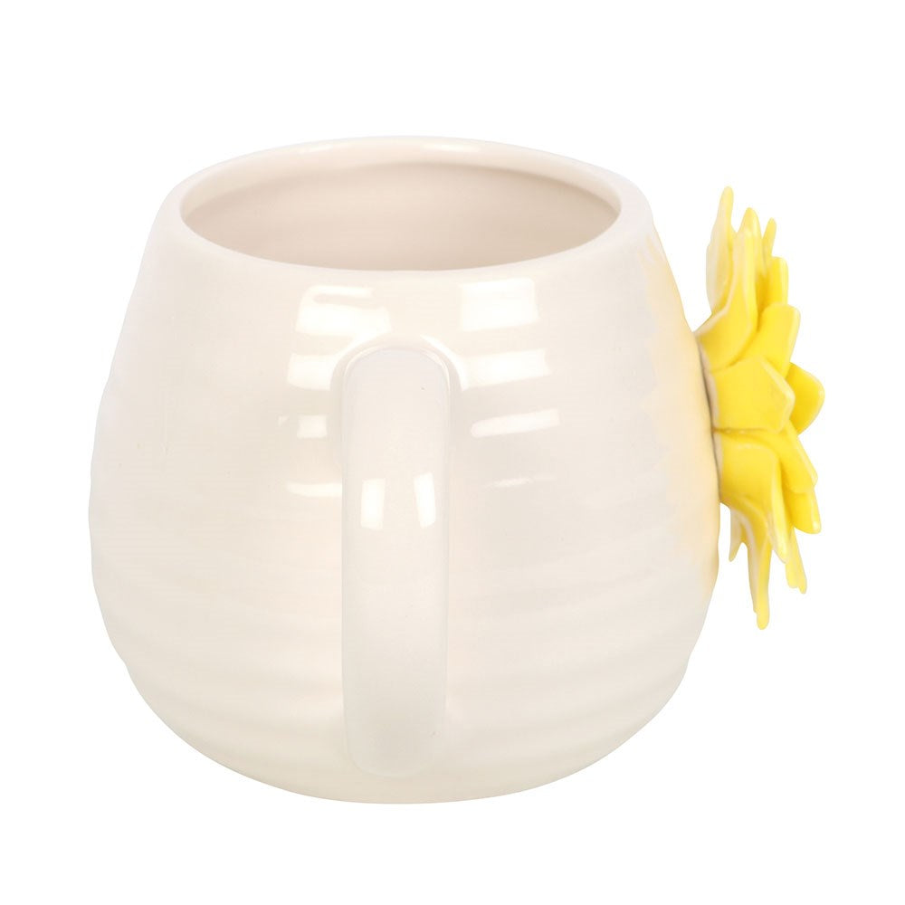 White ceramic mug with a yellow sunflower design on a white background