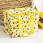 Yellow sunflower insulated lunch bag on a light surface with a woven basket in the background.