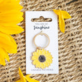 Yellow sunflower keychain on a card with 'You are my sunshine' text, surrounded by sunflowers on a woven surface.