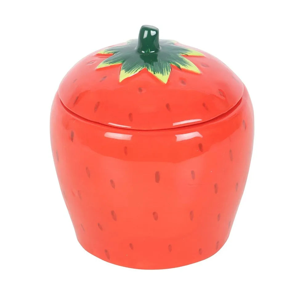 Strawberry-shaped candle container with a green lid on a white background