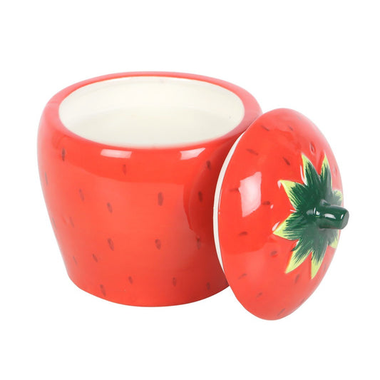 Red ceramic candle shaped like a strawberry with a green leaf on a white background