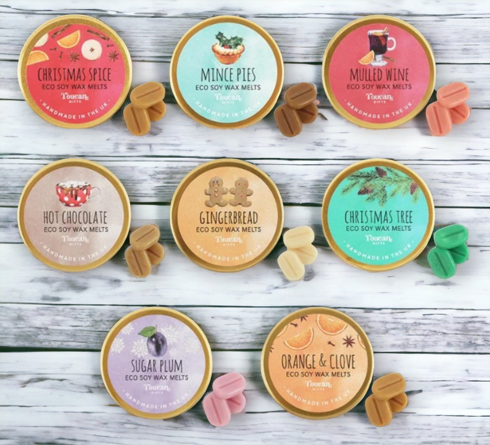A collection of eight eco-friendly soy wax melts in various Christmas-themed fragrances, such as Orange & Clove, Sugar Plum, and Christmas Tree, arranged in an alternating pattern in eco-friendly aluminium tins.