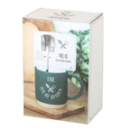 Green mug with spoon set in a box on a wooden surface