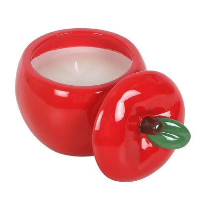 Red apple-shaped candle with a white candle inside on a white background