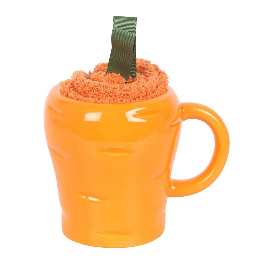 Orange carrot-shaped mug with fluffy cosy socks on a white background