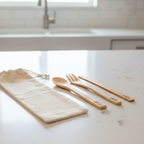 Bamboo cutlery set with a carrying pouch on a kitchen counter