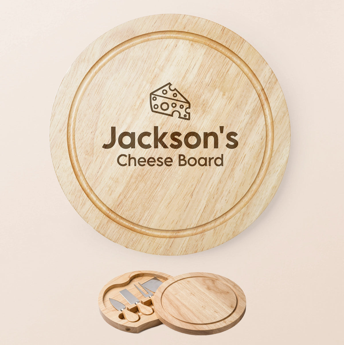 Personalized round wooden cheese board set with a matching wooden lid engraved with ''name' Cheese Board' and a cheese wedge icon, shown on a light beige background with the included cheese knife tools at the bottom.