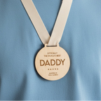 Wooden medal with 'Officially the world's best daddy' text on a white background