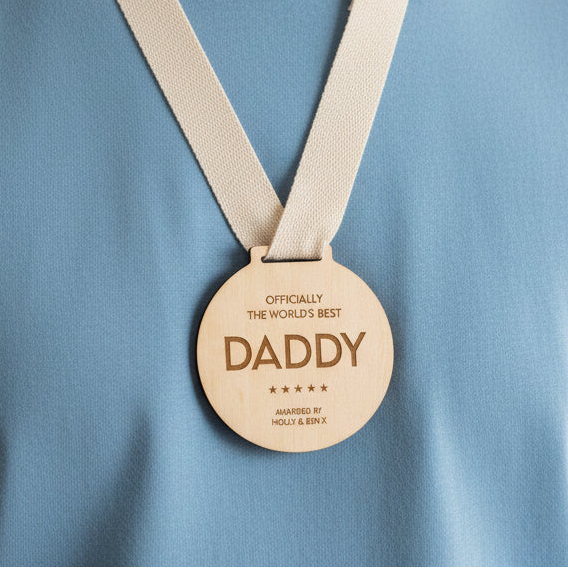 Wooden medal with 'Officially the world's best daddy' text on a white background