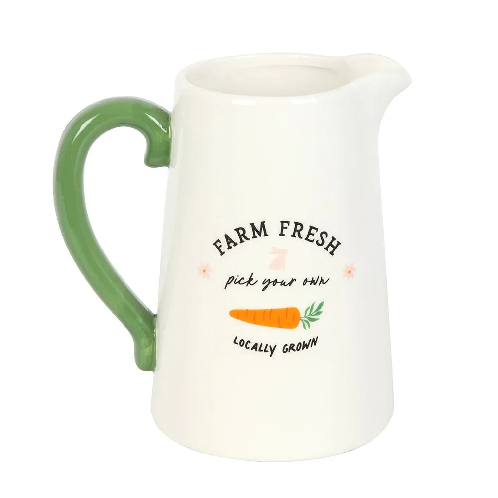 White ceramic pitcher vase with green handle and 'Farm Fresh, Pick Your Own, Locally Grown' text and carrot illustration on a white background.