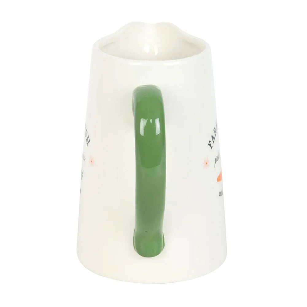 White jug with a green handle on a white background