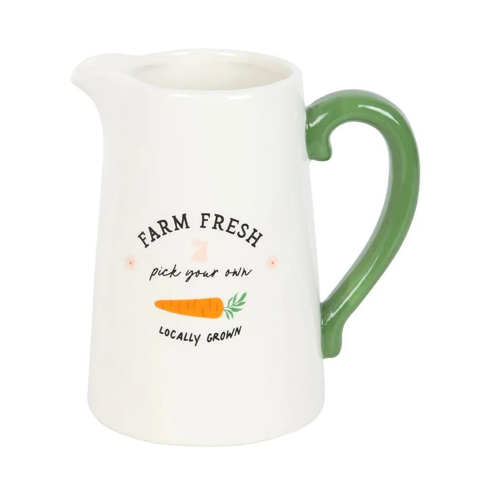 White ceramic pitcher with green handle and 'Farm Fresh' text on a white background