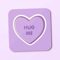 square coaster with love heart inspired design saying 'hug me' on a purple background